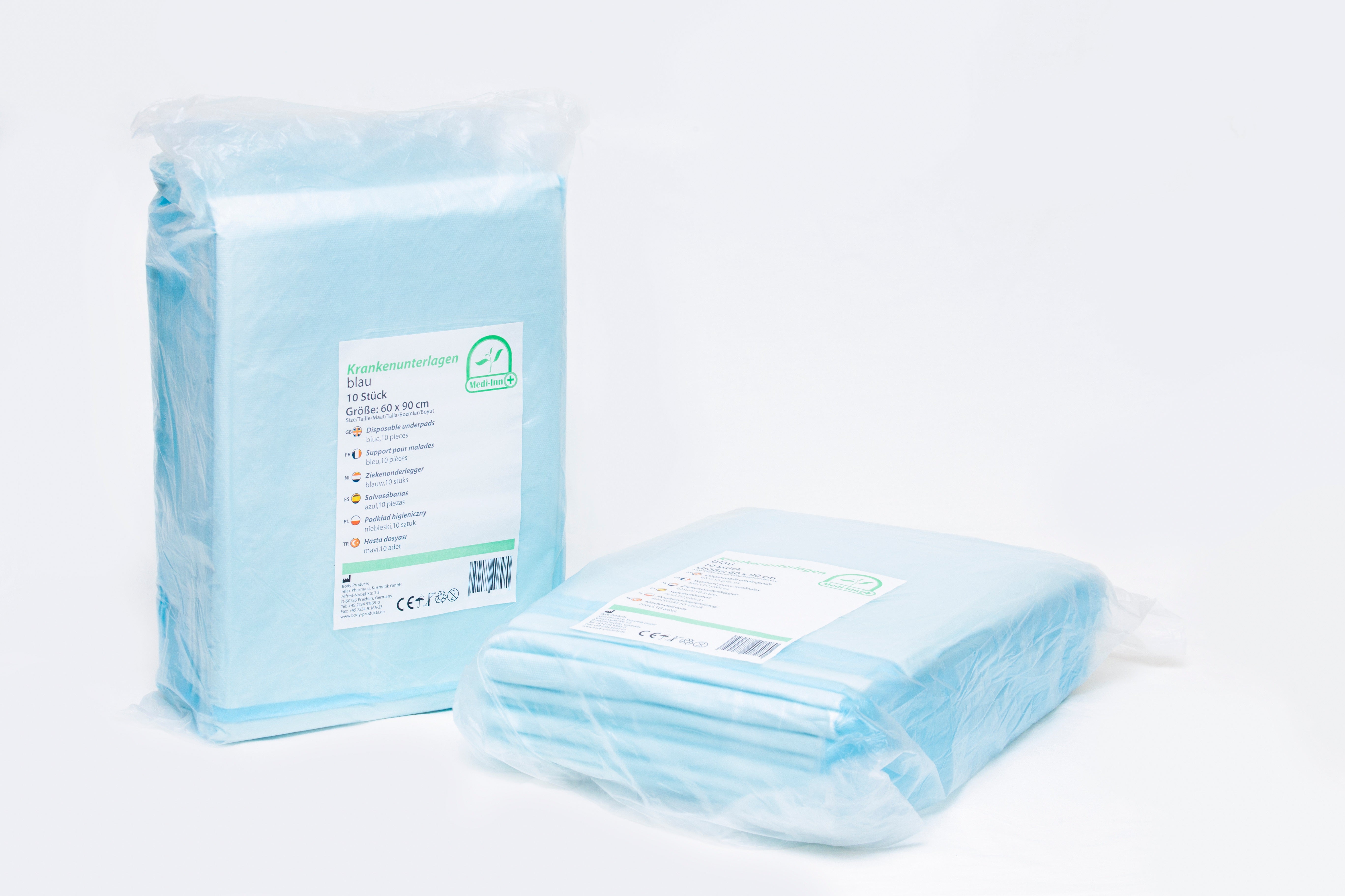 Bild zeigt eine Packung von Medi Inn Einmalunterlagen. Die Vorderseite der Verpackung ist klar und zeigt das Produkt in einer durchsichtigen Folie, mit einer Größe von 60 x 90 cm und einer Stückzahl von 100 unterlagen. Die Unterlagen wirken saugfähig und hygienisch, ideal für den Einsatz in medizinischen Einrichtungen oder bei Pflegeanwendungen. Auf der Verpackung sind außerdem Informationen wie der Markenname, die Produktbezeichnung und Hinweise zur Verwendung deutlich zu erkennen.