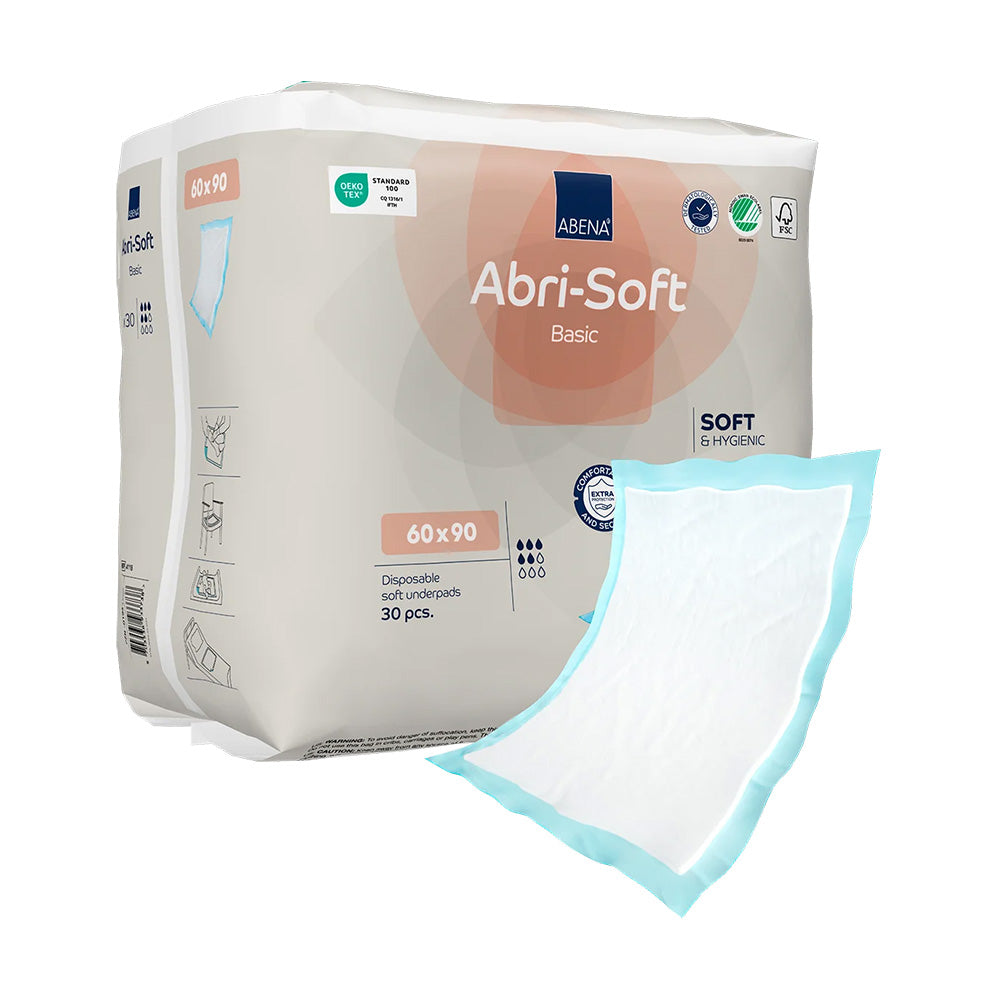 Bild eines Produkts: Abena Abri-Soft Basic Inkontinenzunterlage, Größe 60 x 90 cm. Die Unterlage hat eine helle, bläuliche Farbe mit einem sanften, strukturierten Design. Sie ist in der Mitte gefaltet und leicht schräg auf einer neutralen, hellen Oberfläche platziert. Die Umrandung zeigt eine feine, weiße Kontur. Die Unterlage ist für die Benutzung im Bett oder auf Stühlen gedacht und bietet Schutz vor Nässe.