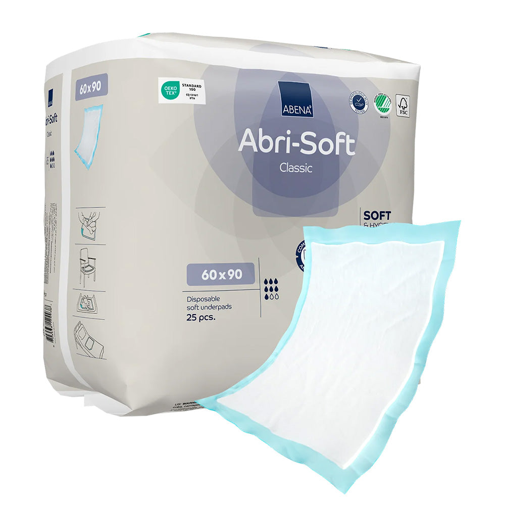 Weißes, faltbares Inkontinenzunterlage von Abena, Modell Abri-Soft Classic, mit den Maßen 60 x 90 cm. Die Unterlage präsentiert sich auf einem hellen Hintergrund und hebt sich durch ihre klare, strukturierte Oberfläche ab. Die Verpackung zeigt das Produktdesign mit einem modernen, ansprechenden Logo. In einer niedrigeren Ansicht wird die gesamte Fläche deutlich, wodurch die Polsterung und die Saugfähigkeit der Unterlage betont werden.