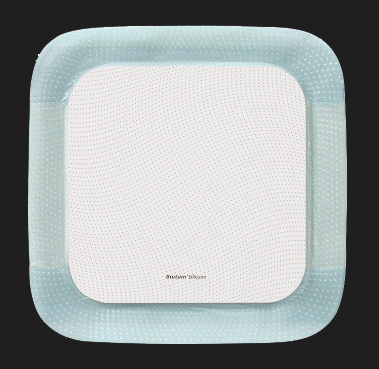 Bildbeschreibung für ein Biatain Silikon-Schaumpflaster mit einer Größe von 10 x 10 cm. Das Pflaster ist quadratisch und besteht aus einem weichen, flexiblen Silikonmaterial, das auf einer saugfähigen Schaumstoffschicht basiert. Die Oberfläche des Pflasters ist hell und schimmert leicht, während die Ränder abgerundet sind. Es befindet sich auf weißem Hintergrund, der die Details des Produkts hervorhebt.