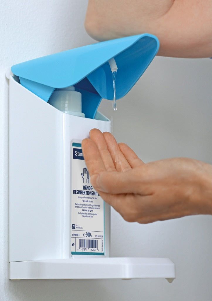 Bild eines Euro-Spenders „Safety Plus“, der für automatische Desinfektionsmittel-Abgabe konzipiert ist. Der Spender hat ein modernes, elegantes Design in Weiß mit einem transparenten Tank, der den Füllstand des Desinfektionsmittels anzeigt. Die Bedienung erfolgt berührungslos über einen Sensor an der Vorderseite. An der oberen Seite befindet sich eine Öffnung für einfache Befüllung.