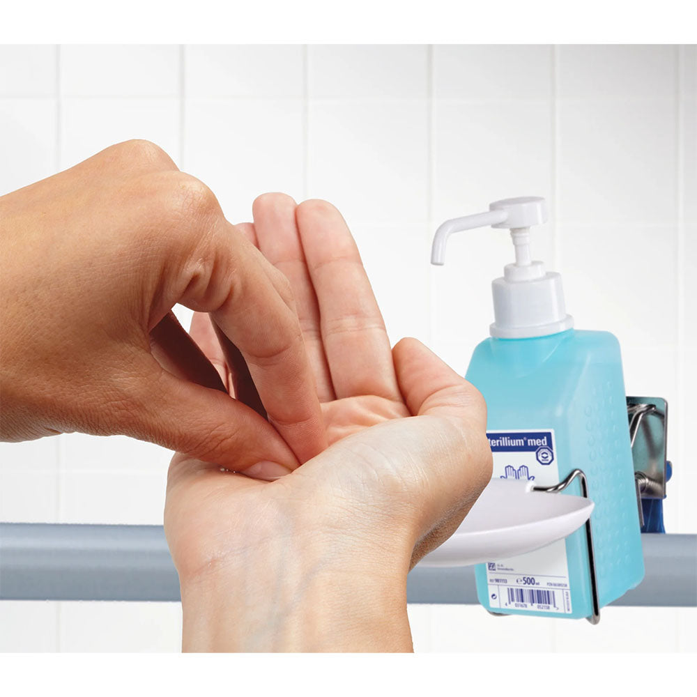 Das Bild zeigt eine Nahaufnahme der Anwendung des Bode Sterillium Med, einem Desinfektionsmittel für die Hände. Eine Hand hält eine kleine Menge des transparenten Gels, das auf die andere Hand aufgetragen wird. Die Hände befinden sich vor einem neutralen Hintergrund. Die Oberfläche der Hände ist leicht glänzend durch das Gel. Angedeutete Texturen und Falten in den Händen sind sichtbar, was die Natürlichkeit der Anwendung unterstreicht. Das Produkt ist für schnelle Hygiene und Desinfektion konzipiert.