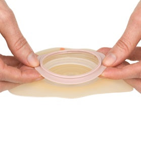 Produktbild der Dansac NovaLife 2 Convex Basisplatte, Packung mit 5 Stück. Die Basisplatte hat einen Durchmesser von 30 mm und ist in einem klaren, hygienischen Plastik eingeschweißt. Im Vordergrund ist die Verpackung sichtbar, versehen mit dem Markenlogo „Dansac“ und der Produktbezeichnung „NovaLife 2 Convex“. Die Basisplatte ist für Menschen mit Stomata konzipiert und bietet eine konvexe Form für besseren Sitz.