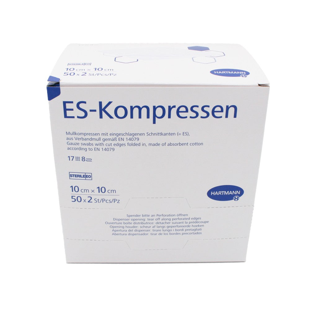 Ein Paket mit sterilen Mullkompressen von Hartmann, Größe 10 cm x 10 cm. Die Verpackung ist in einer klaren, durchsichtigen Folie dargestellt, die den Inhalt sichtbar macht. Die Kompressen sind zu einem kompakten Stapel gefaltet und übereinandergelegt. Auf der Vorderseite der Verpackung sind Produktinformationen in deutscher Sprache abgedruckt, darunter der Markenname „Hartmann“, die Sterilität und die Anzahl der 17-fadigen Kompressen.