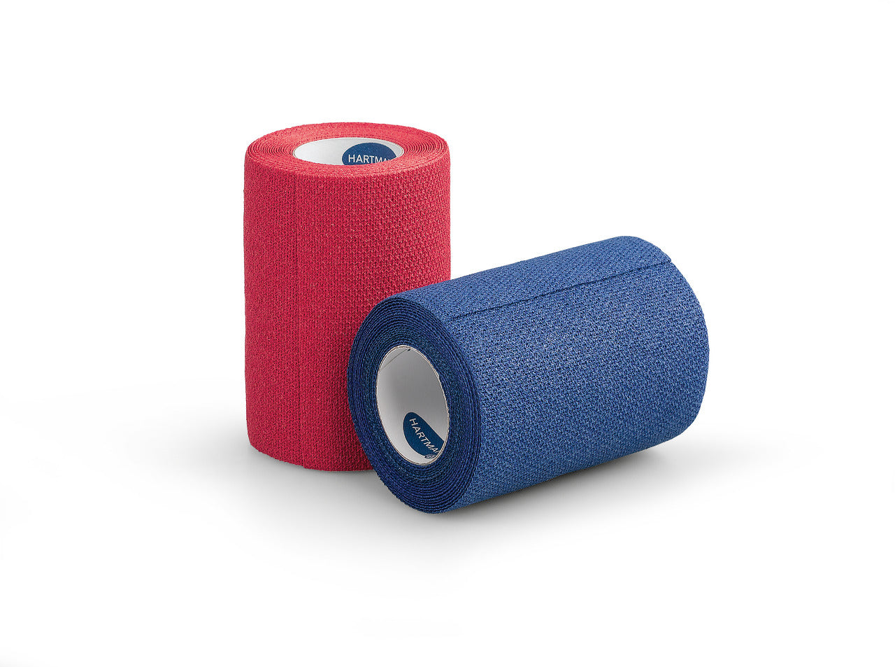 Produktbild: Eine Packung von Hartmann Idealast Haft Color mit einem Verband, der rotes elastisches Material zeigt. Die Packung enthält einen Verband mit einer Breite von 6 cm und einer Länge von 4 m. Der Verband ist in einer transparenten Umverpackung präsentiert, auf der das Produktetikett gut sichtbar ist. Das Etikett zeigt den Markennamen "Hartmann", den Produkttyp "Idealast Haft Color", die Maße sowie die Farbe Rot. Die Hintergrundfarbe der Verpackung ist neutral und hebt den farbigen Verband hervor.
