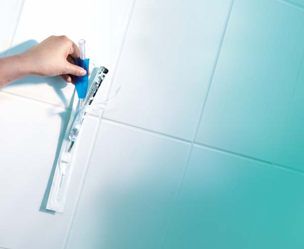 Produktbild eines Liquick Base Tiemann Katheters, 14 Fr, 40 cm, in einer transparenten Verpackung. Die Verpackung ist auf der linken Seite sichtbar, mit Weiß- und Blautönen, auf dem Aufdruck sind Produktinformationen und das Logo der Marke zu erkennen. Rechts sind die Katheter durch eine Öffnung sichtbar, die längliche, geschwungene Form ist deutlich zu sehen.