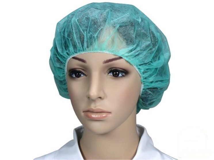 Ein Produktbild zeigt eine blau gefärbte Einweghaube aus Vlies für den Kopf. Die Haube hat einen runden, nach außen gewölbten Rand, der den elastischen Gürtel zur sicheren Befestigung des Kopfteils anzeigt. Die Färbung ist gleichmäßig, ohne sichtbare Muster oder Verzierungen. Der Hintergrund ist neutral und hell, wodurch das Produkt gut zur Geltung kommt.