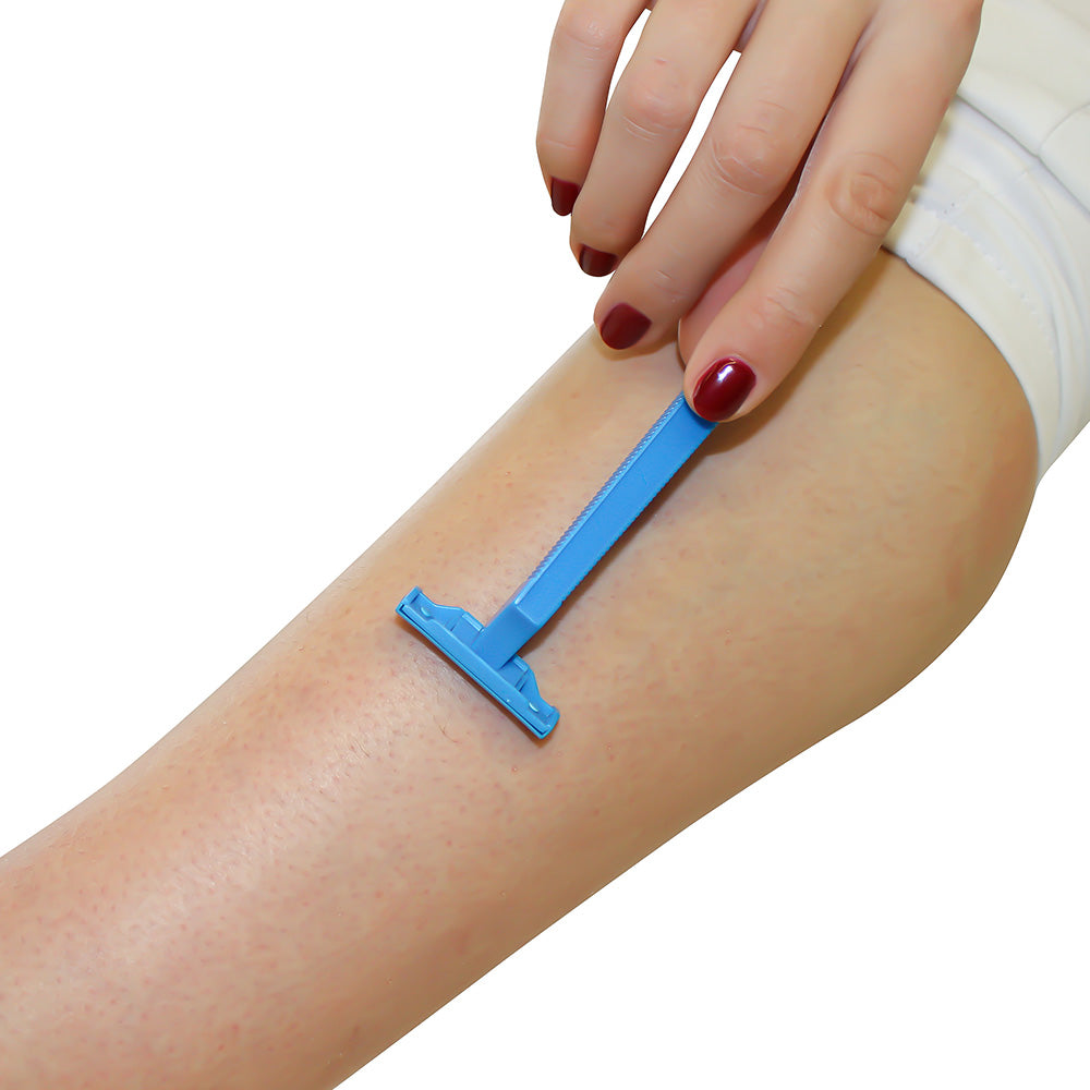 Ein blauer Einmalrasierer mit einem ergonomischen Griff liegt auf einem weißen Hintergrund. Der Rasierer hat eine schmale, abgerundete Klinge für eine präzise Rasur. Der Griff ist leicht geschwungen, um einen komfortablen Halt zu bieten. An der Rückseite des Rasierers ist deutlich die Einweg-Natur zu erkennen, da kein Ersatzteil oder zusätzliche Klingen sichtbar sind. Der Rasierer ist in einem frischen, modernen Design gehalten, das sowohl Funktionalität als auch ansprechendes Aussehen vereint.