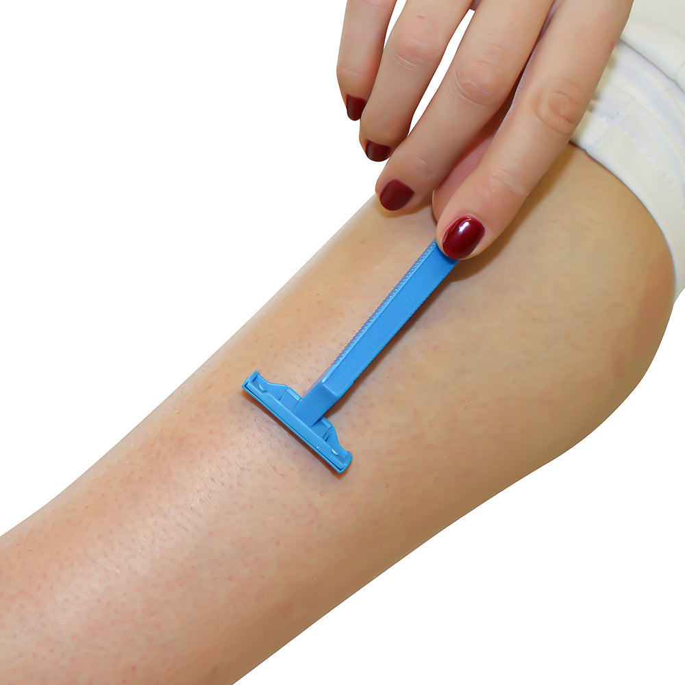 Ein blauer Einwegrasierer mit zweischneidigen Klingen liegt auf einem weißen Hintergrund. Der Rasierer hat einen ergonomischen Griff, der für eine bequeme Handhabung sorgt. Die Klingen sind optimal angeordnet, um eine glatte Rasur zu gewährleisten. Der Rasierer ist leicht und kompakt, ideal für Reisen oder den täglichen Gebrauch. Im Hintergrund sind keine zusätzlichen Objekte erkennbar, wodurch das Produkt im Fokus steht.
