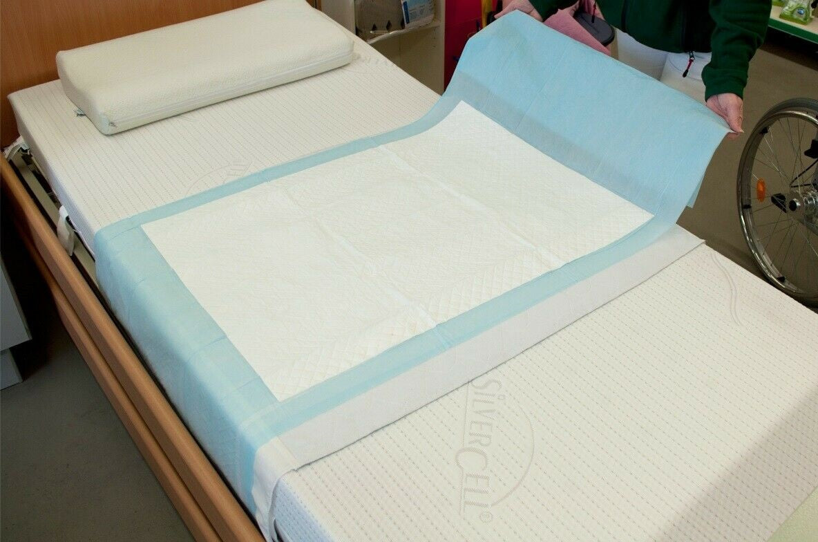 Das Bild zeigt eine Packung mit Krankenunterlagen der Marke Medi Inn. Die Unterlagen sind im Premium-Design und messen 70 x 175 cm. Auf der Verpackung sind ansprechende Grafiken abgebildet, die die Verwendung der Unterlagen im medizinischen Bereich hervorheben. Die Verpackung ist farblich ansprechend gestaltet und enthält klare Informationen zu den Produkten, einschließlich der Materialbeschreibung und des Anwendungsbereichs.