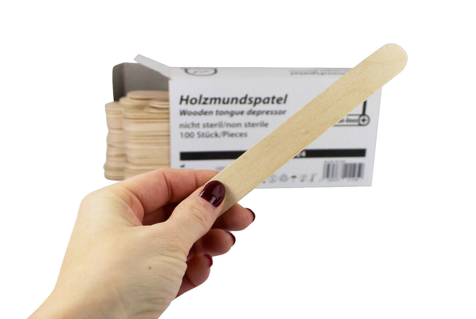 Bild von einem Paket mit 100 Holz-Mundspateln in verschiedenen Größen, die ordentlich verpackt sind. Die Spatel sind hellbraun und haben eine glatte Oberfläche ohne Risse oder Verunreinigungen. Neben dem Produkt ist eine Maßaufnahme sichtbar, die die Länge der Spatel betont. Der Hintergrund ist neutral, um das Produkt hervorzuheben. Die Verpackung ist klar und zeigt den Markennamen "Medi Inn", zusammen mit einem Hinweis auf die Verwendung für medizinische und kosmetische Zwecke.