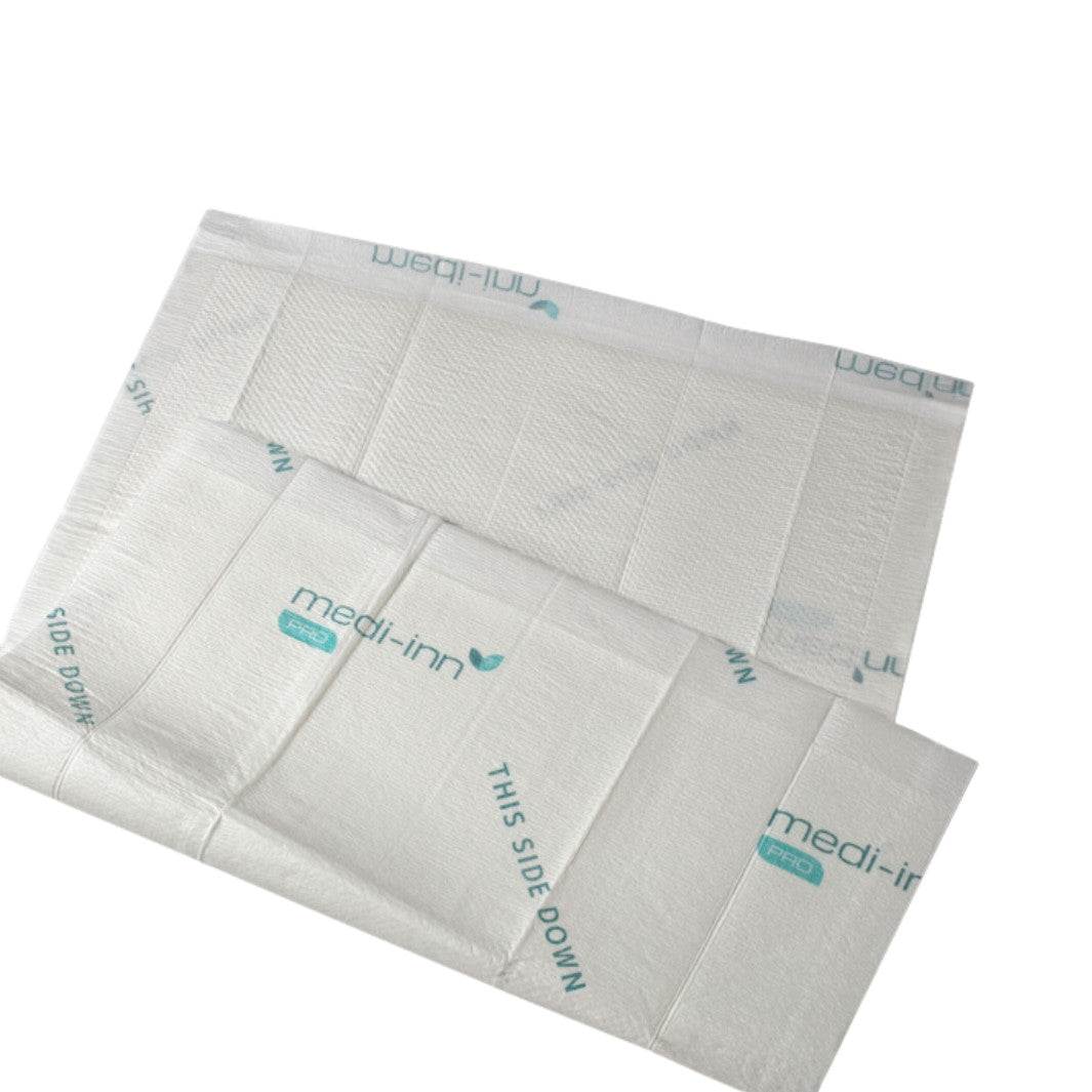 Weißes Krankenunterlagen-Produkt, das auf einem blauen Hintergrund präsentiert wird. Die Unterlage hat die Maße 60 cm x 90 cm und wird als extrem saugfähig beschrieben. Auf der Verpackung sind klare, lesbare Informationen zum Produkt, seinen Anwendungen und Vorteilen aufgedruckt. Es handelt sich um eine hygienische Schutzunterlage, die ideal für den Einsatz in der Pflege oder für Haustiere geeignet ist.