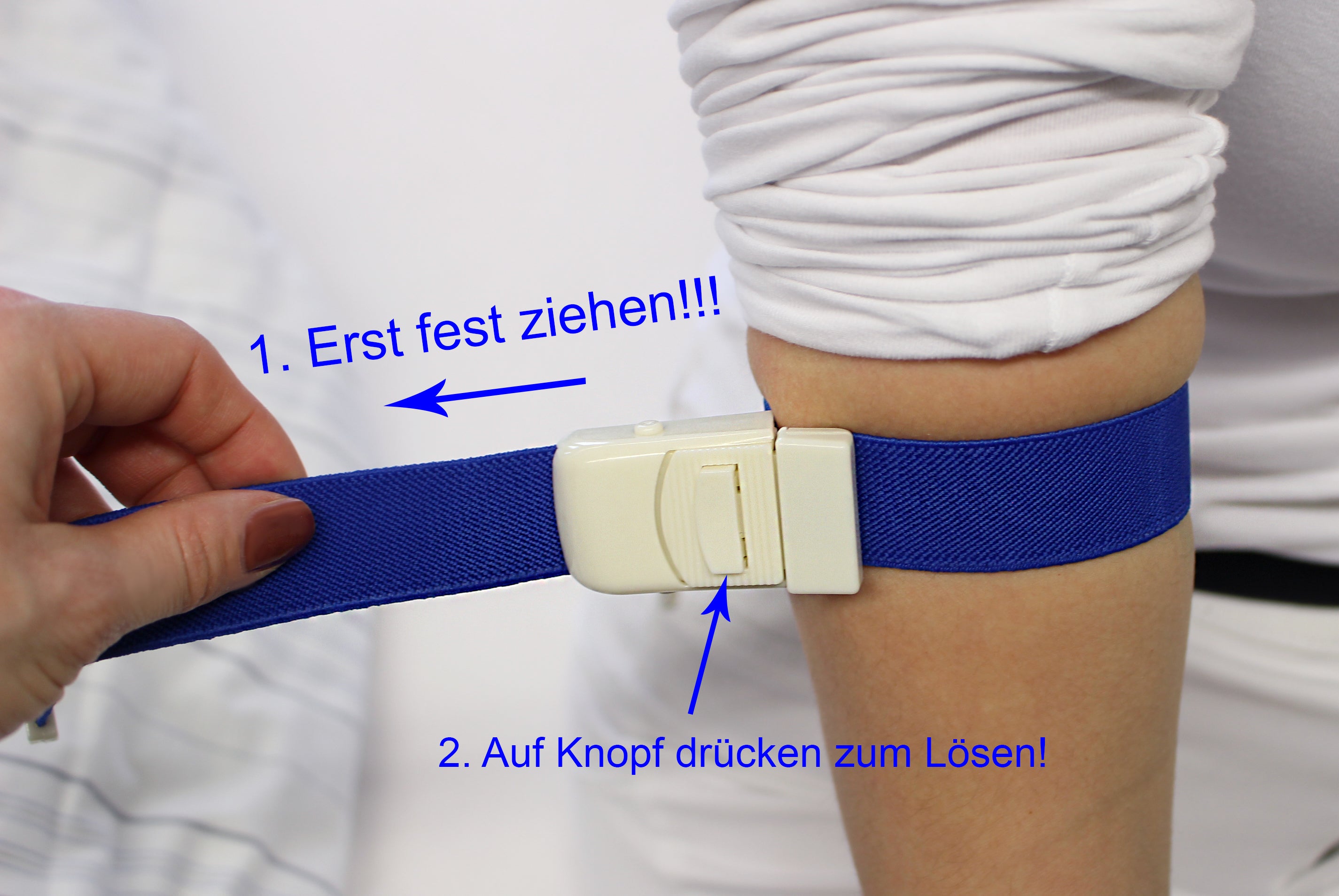 Bild eines blauen Venenstauers (Tourniquet) aus einem elastischen Material, der für medizinische Zwecke verwendet wird. Der Stauschlauch ist in der Mitte leicht verengt, um eine effektive Absperrung des Blutflusses zu ermöglichen. An einem Ende befindet sich ein stabiler Kunststoffverschluss zur sicheren Befestigung. Der Hintergrund ist hell, wodurch der Venenstauer gut zur Geltung kommt.