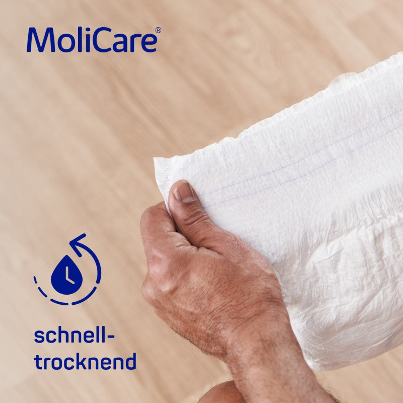Alt-Text: Auf dem Bild ist eine Packung „MoliCare Premium Mobile“ zu sehen. Die Verpackung ist in einem ansprechenden Design gehalten, mit einem überwiegenden Blau und weißen Farbtönen. Auf der Vorderseite sind die Produktbezeichnung sowie die Angabe „10 Tropfen“ und die Größe „M“ deutlich abgebildet. Im Hintergrund sind stilisierte graphische Elemente, die den funktionalen Charakter des Produkts hervorheben.