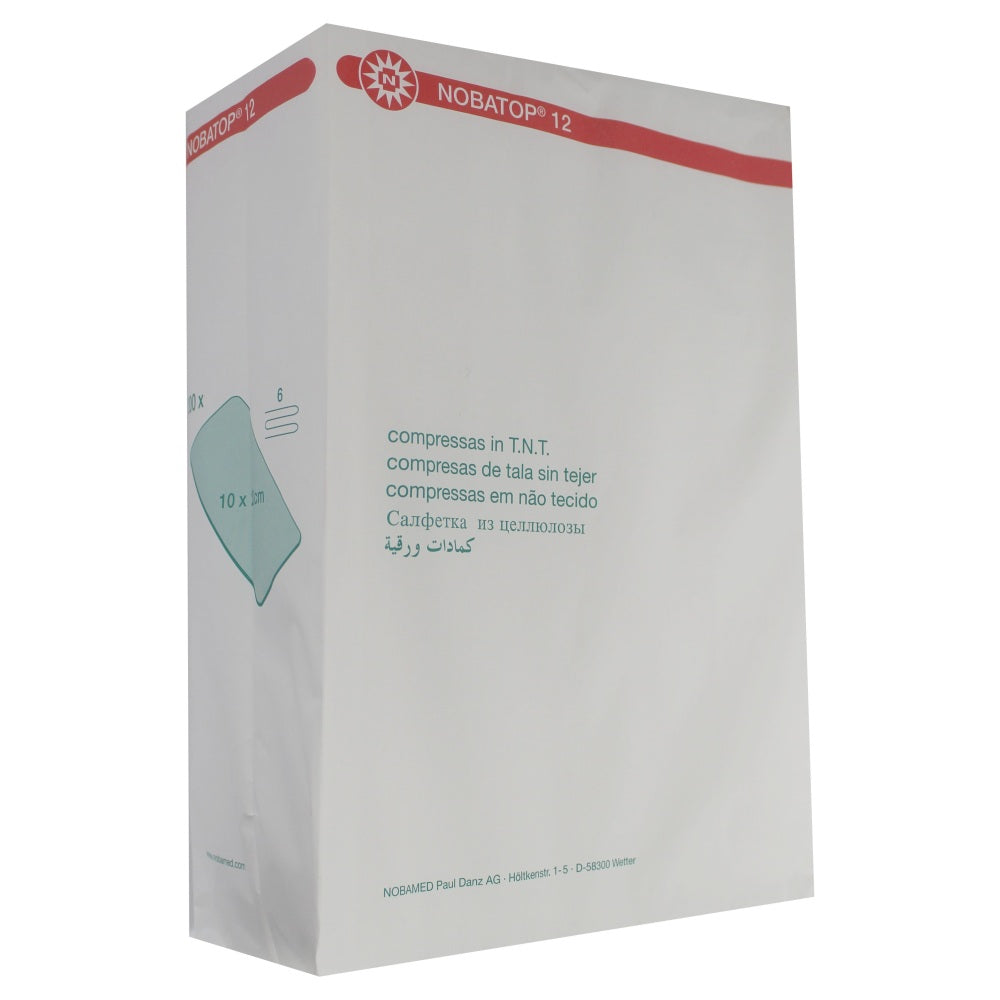 Weißer Verpackungskarton mit lichtblauer Beschriftung in der Mitte, die das Produkt beschreibt: "Noba Nobatop 12 Vliesstoffkompressen, 6-fach, 200er Pack". Auf der Vorderseite ist eine Packungsgröße von 10 cm x 10 cm angegeben. Im Hintergrund sind die Kompressen selbst zu sehen, die ordentlich gestapelt sind, mit einem sichtbaren Vliesstoff-Muster. Die Verpackung hat eine klare, hygienische Darstellung, die darauf hindeutet, dass es sich um sterile Kompressen handelt, geeignet für medizinische Anwendungen.