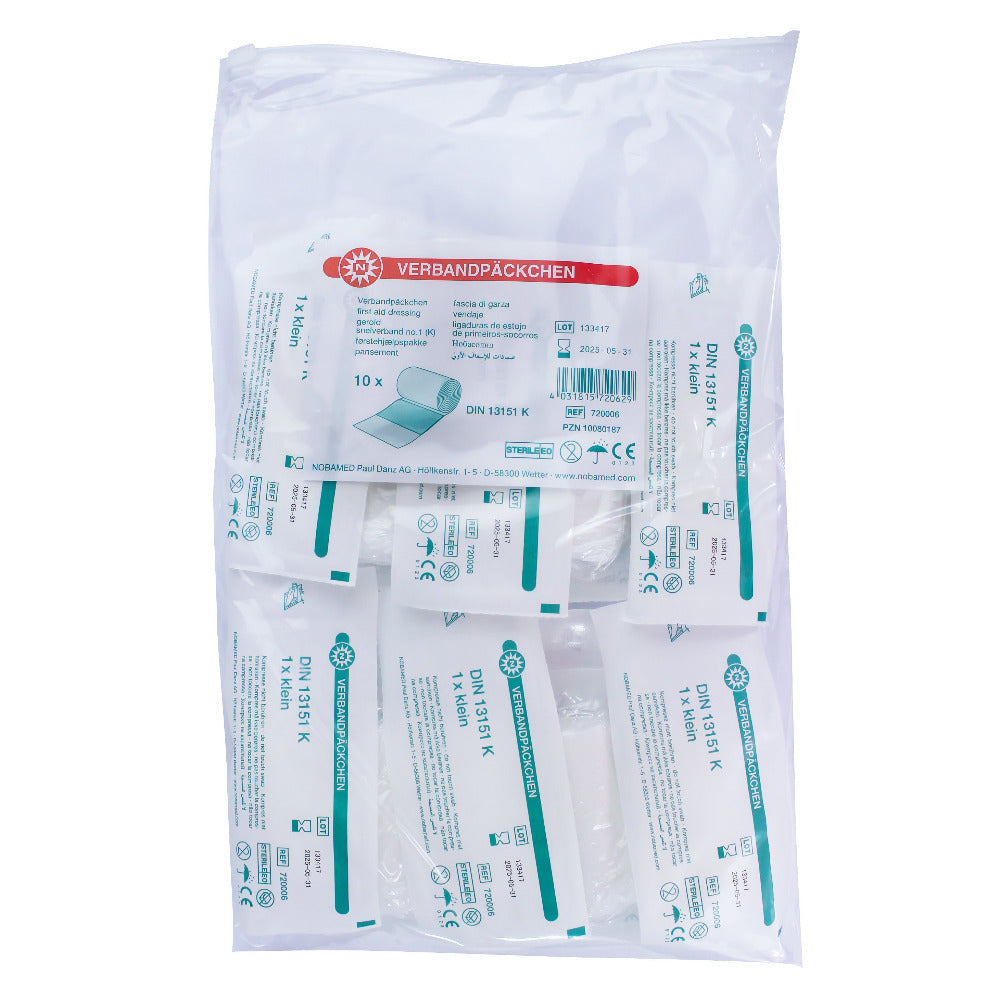 Ein Verbandpäckchen im steril verpackten Zustand, das auf einem weißen Hintergrund liegt. Die Verpackung hat eine transparente Folie, die den Inhalt sichtbar macht. Das Designerlabel „noba“ ist klar erkennbar und in einer typischen Farbkombination gestaltet. Das Produkt erfüllt die DIN-Norm 13151 und ist mit einem entsprechenden Hinweis auf der Verpackung versehen. Neben dem Label sind die Produktinformationen gut lesbar.
