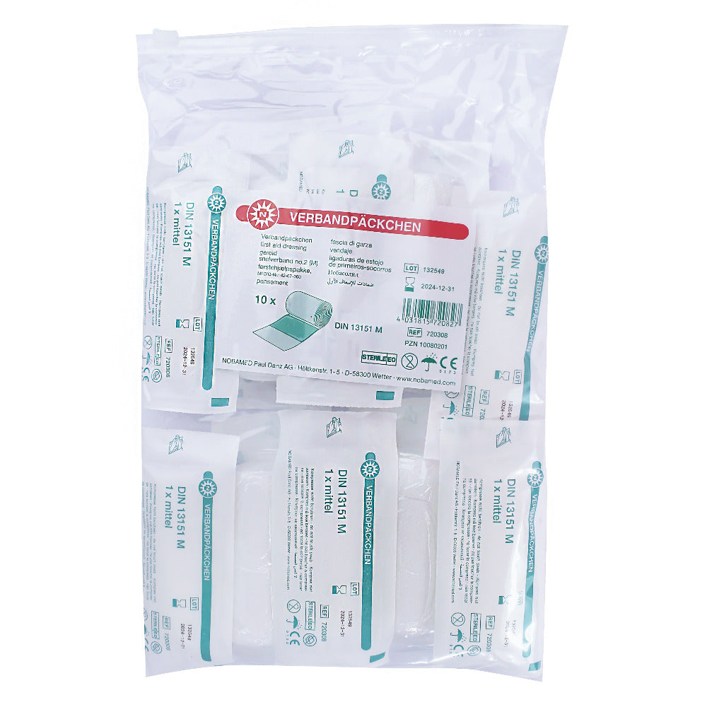 Das Bild zeigt ein steril verpacktes Verbandpäckchen nach DIN 13151. Die Verpackung ist transparent und bietet einen klaren Blick auf den Inhalt, der aus einem kompakten, gut organisierten Set von Verbandsmaterialien besteht. Es sind antiseptische Wundauflagen, eine elastische Binde und eine Instruktionskarte zu sehen. Insgesamt vermittelt das Bild den Eindruck von Hygiene und Professionalität, ideal für den Einsatz in Erste-Hilfe-Situationen.