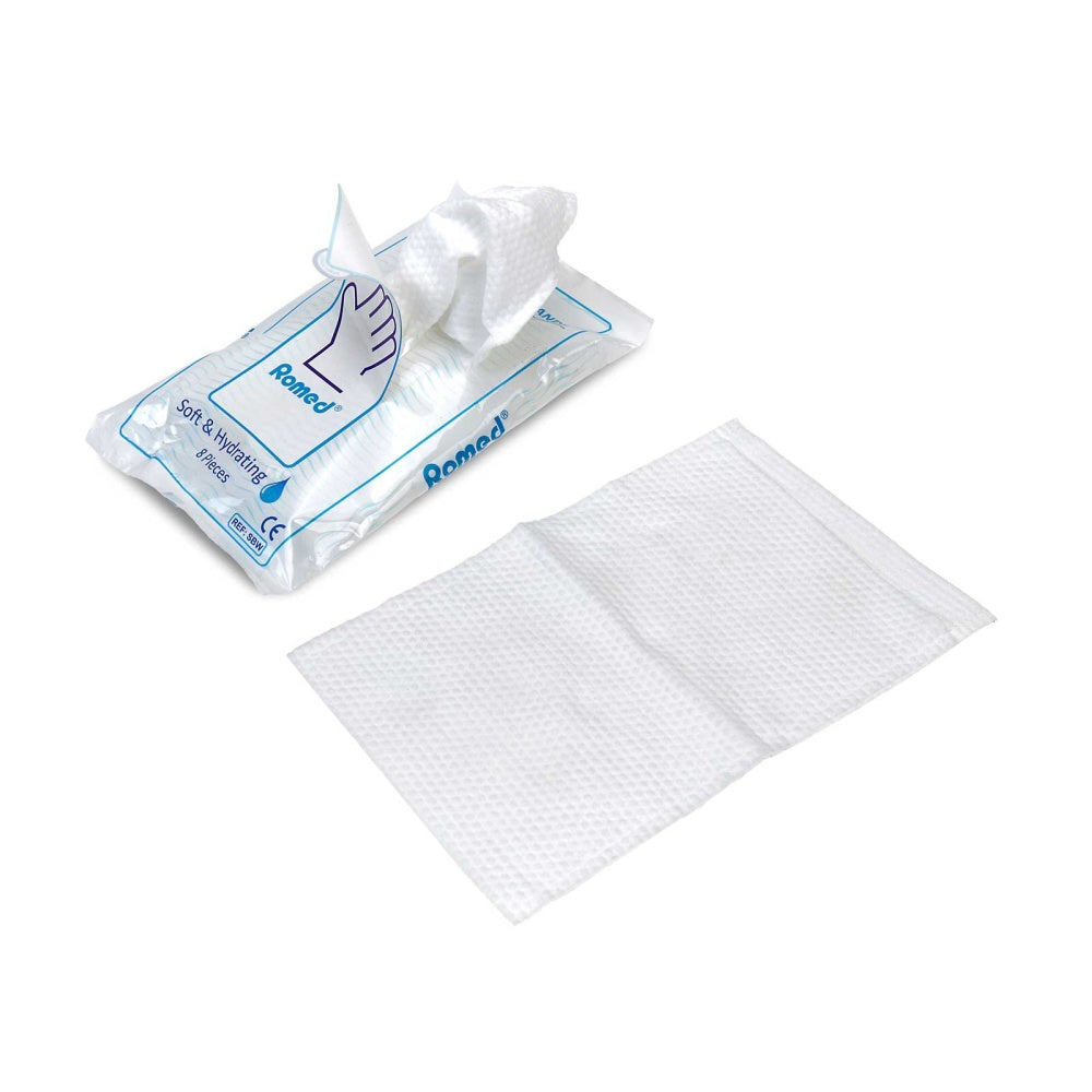 Ansicht eines ausgepackten Romed Einmal-Waschhandschuhes neben der geöffneten Verpackung.