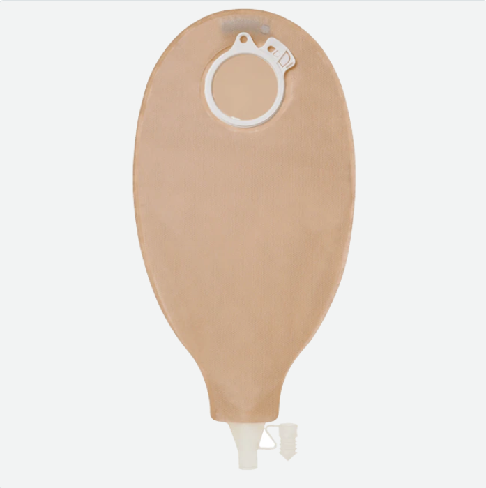 Ein Sensura Click Ileostoma-Drainagebeutel, präsentiert in einer klaren Verpackung, steht im Mittelpunkt des Bildes. Der Beutel hat eine beige, weiche Oberfläche mit einem transparenten, abgerundeten Teil an der Oberseite. An der Seite des Beutels befindet sich ein praktischer Klippverschluss. Das Produkt ist mit einem Etikett versehen, das wichtige Informationen zur Verwendung und Handhabung enthält.