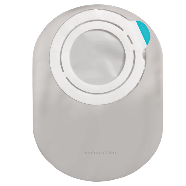 Bild eines Sensura Mio Flex Kolostomiebeutels in Lichtgrau mit einem Fassungsvermögen von 320 ml. Der Beutel hat eine glatte, leicht strukturiert erzielte Oberfläche und ist mit einem flexiblen, hautfreundlichen Klebestreifen ausgestattet, der eine sichere Haftung gewährleistet. In der oberen linken Ecke ist ein komfortabler Ausgang für den Kolostomie-Stoma sichtbar. Der Beutel ist so gestaltet, dass er diskret und komfortabel unter der Kleidung getragen werden kann.