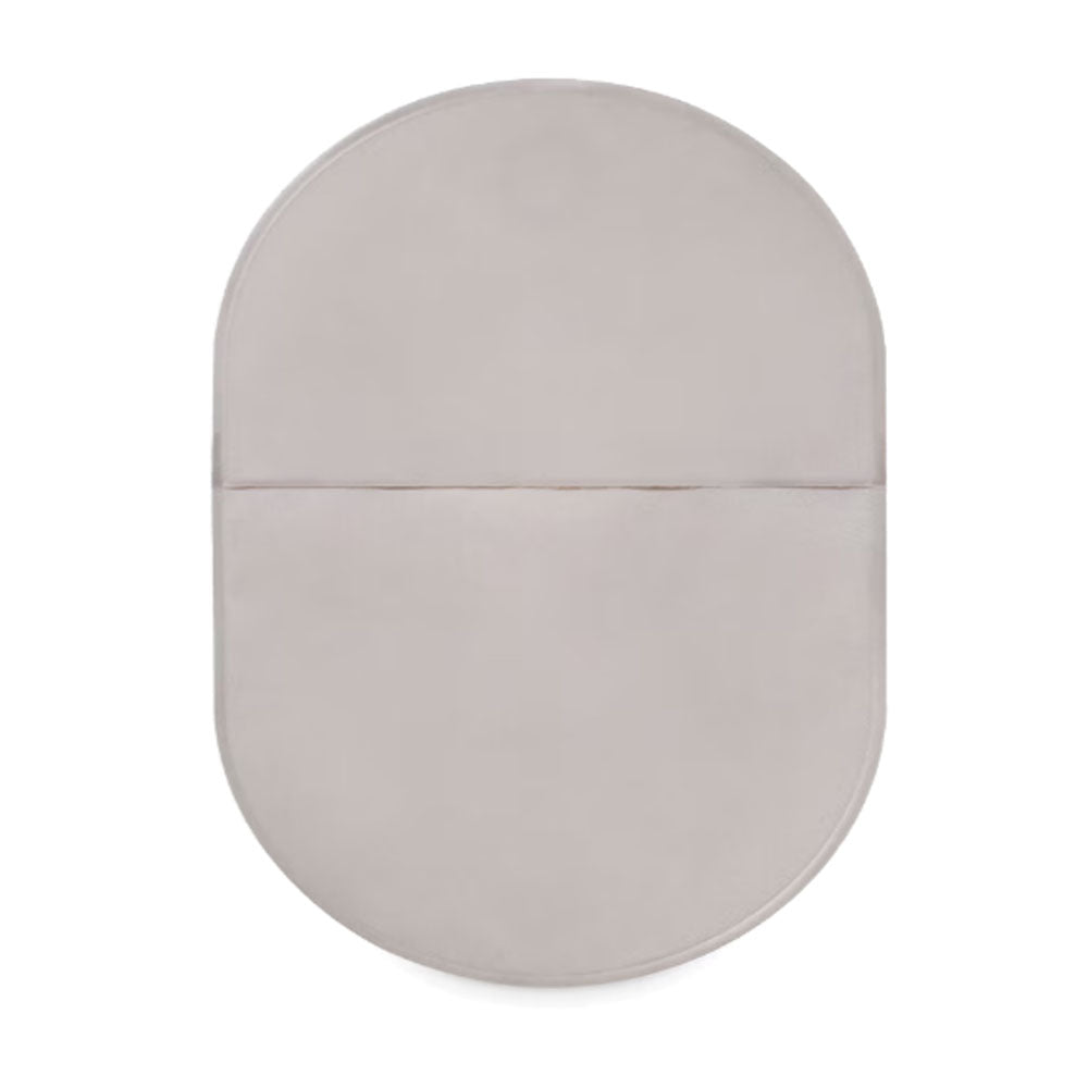 Sensura Mio Kolostomiebeutel in einer transparenten Verpackung. Der Beutel hat eine ovale Form und ist in sanften Farben gehalten. An der Oberseite sind Befestigungsöffnungen für Stomaplastiken sichtbar. Die Oberfläche des Beutels ist glatt und leicht glänzend, während die Rückseite ein flexibles Material aufweist, das für Komfort sorgt. Der Beutel ist für eine sichere und diskrete Verwendung konzipiert, um eine einfache Handhabung zu gewährleisten.