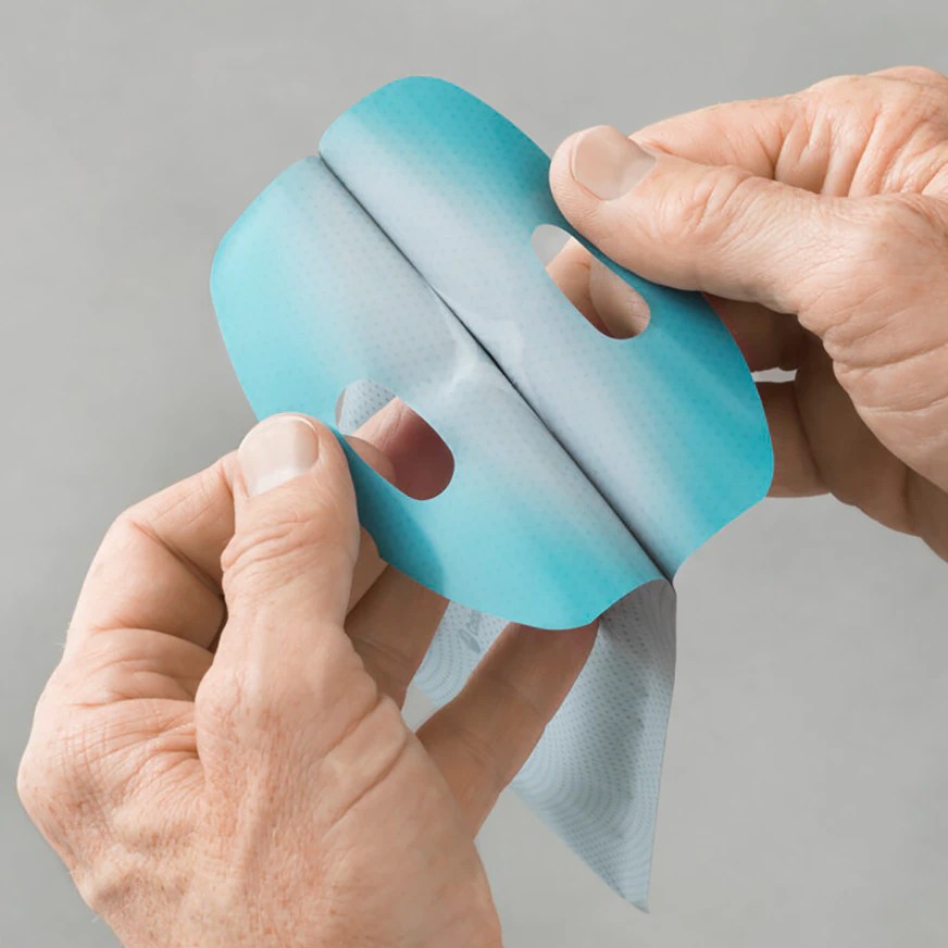 Bildbeschreibung eines SpeediCath Flex Katheters für Männer. Der Katheter ist in einer klaren Verpackung dargestellt, die den Inhalt sichtbar macht. Er hat eine schlanke, flexible Form und ist aus einem smoothen, medizinischen Material gefertigt. Neben dem Katheter sind auch die Hygieneverpackung und eine Anleitung sichtbar. Der Hintergrund des Bildes ist neutral, was die Produkte in den Fokus rückt.