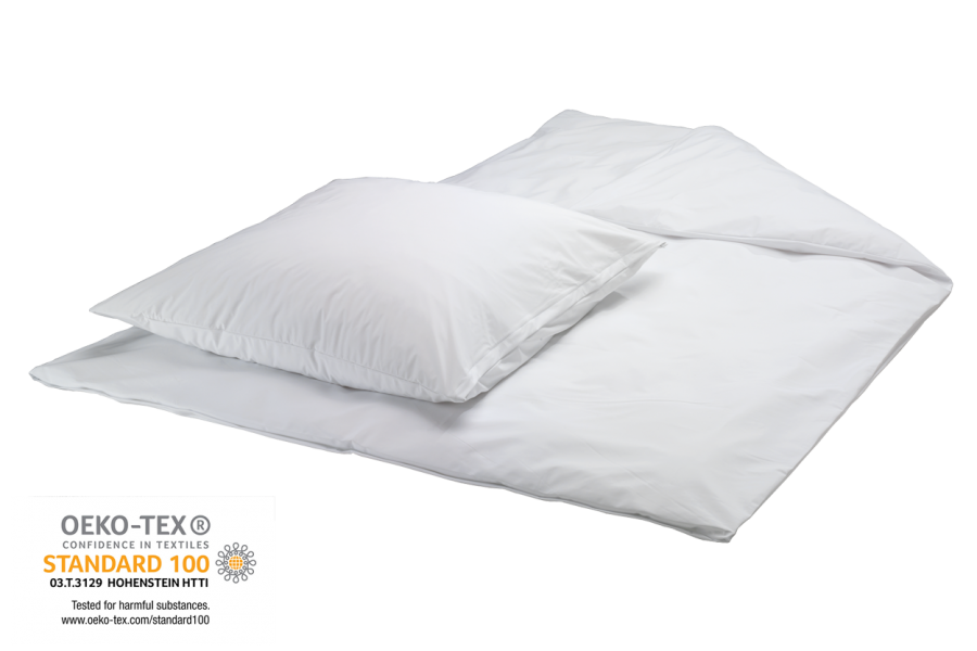 Ein eleganter, weißer Bettbezug von Suprima, auf einem modernen Bett aus hellem Holz drapiert. Der Bezug ist aus hochwertigem, pflegeleichtem Material gefertigt, das eine sanfte, matte Oberfläche zeigt. Er ist mit einem dezenten, stilvollen Design versehen und hat an den Rändern eine feine Naht. Um das Bett herum sind Kissen in verschiedenen Größen arrangiert, die dem Gesamtbild eine ansprechende Optik verleihen. Der Hintergrund ist neutral, was die Aufmerksamkeit auf den Bettbezug lenkt.