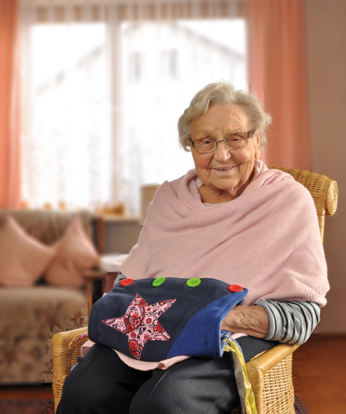 Bild eines hochwertigen, einfarbigen Demenzmuffs, der auf einem neutralen Hintergrund präsentiert wird. Der Muff ist aus weichem, strapazierfähigem Material gefertigt und besitzt eine Vielzahl von sensomotorischen Elementen. Verschiedene Texturen, Farben und kleine Taschen laden zum Fühlen und Entdecken ein, um die motorischen Fähigkeiten von Personen mit Demenz zu stimulieren. Der Muff ist so gestaltet, dass er sowohl Wärme bietet als auch eine beruhigende Beschäftigungsmöglichkeit darstellt.